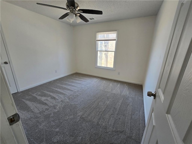 carpeted spare room featuring a textured ceiling, ceiling fan, visible vents, and baseboards