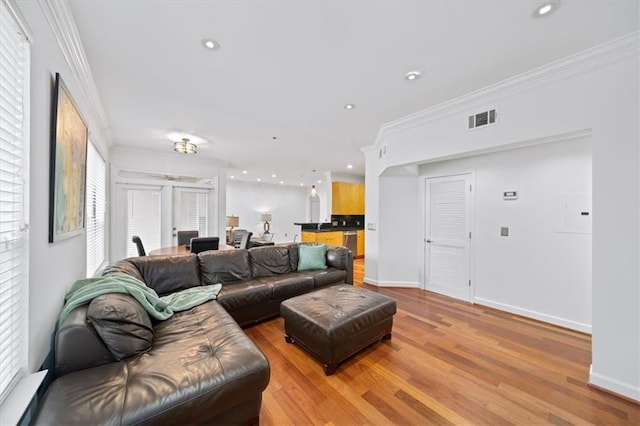 living room with crown molding and light hardwood / wood-style floors