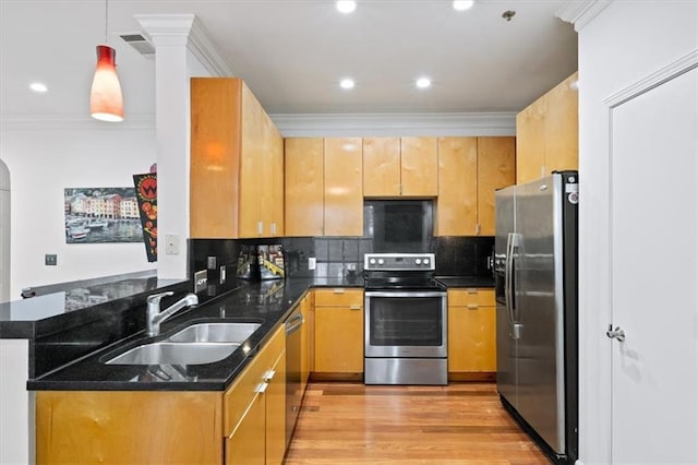 kitchen featuring decorative light fixtures, sink, dark stone counters, kitchen peninsula, and stainless steel appliances