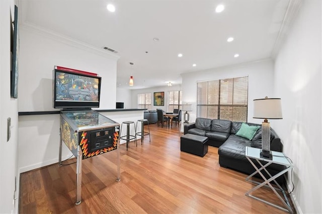 living room with crown molding and light hardwood / wood-style flooring