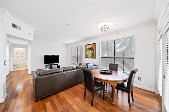 dining space with hardwood / wood-style flooring and crown molding