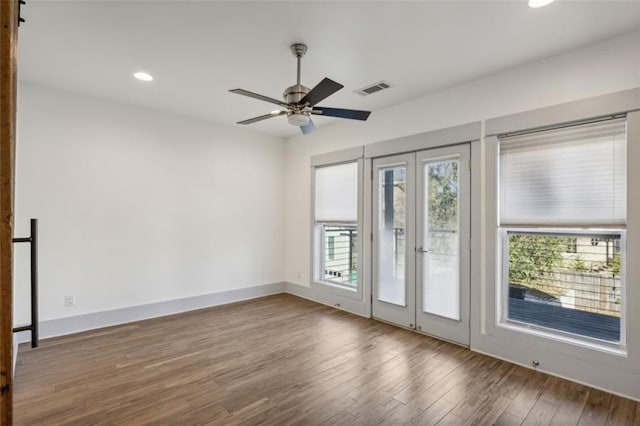 empty room with visible vents, baseboards, wood finished floors, recessed lighting, and french doors