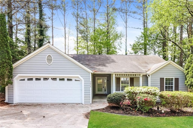 ranch-style house featuring an attached garage, a shingled roof, and concrete driveway