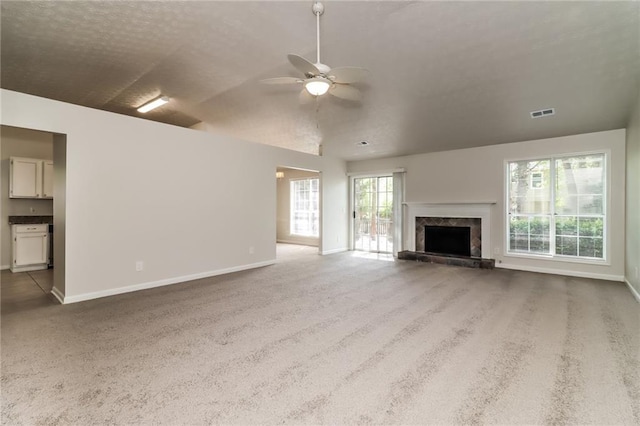unfurnished living room featuring carpet flooring, baseboards, and ceiling fan