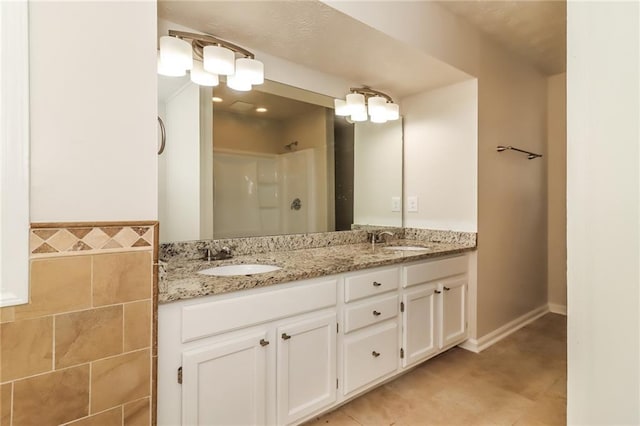 full bath with tile patterned flooring, a sink, a shower, and double vanity