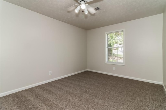 unfurnished room with a textured ceiling, visible vents, baseboards, a ceiling fan, and dark carpet