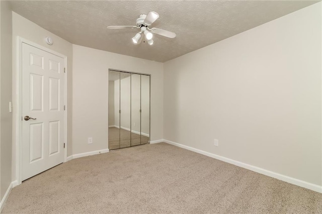 unfurnished bedroom featuring baseboards, carpet floors, and a textured ceiling