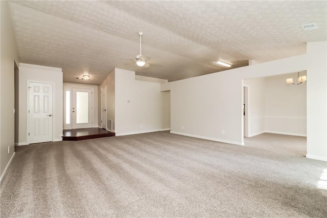 unfurnished room featuring ceiling fan with notable chandelier, carpet floors, baseboards, and a textured ceiling