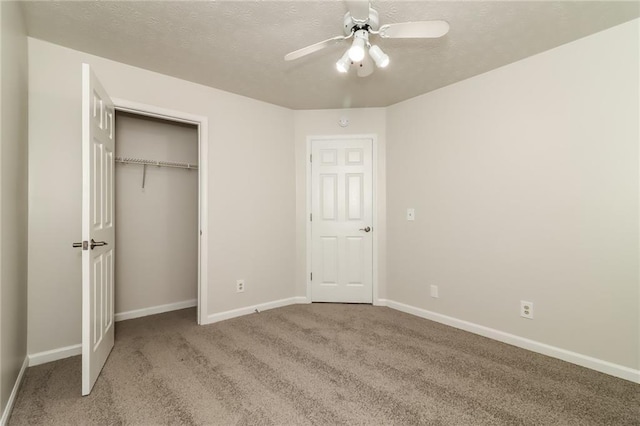 unfurnished bedroom with a closet, a textured ceiling, carpet flooring, and baseboards