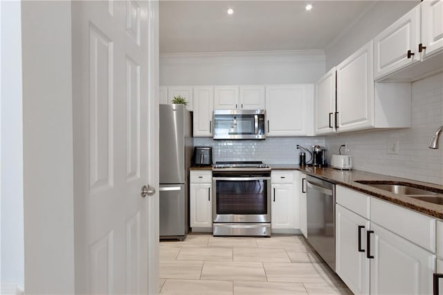 1850 Cotillion Dr Unit 2304, Dunwoody, GA 30338 - kitchen with appliances with stainless steel finishes, a sink, white cabinetry, decorative backsplash, and crown molding
