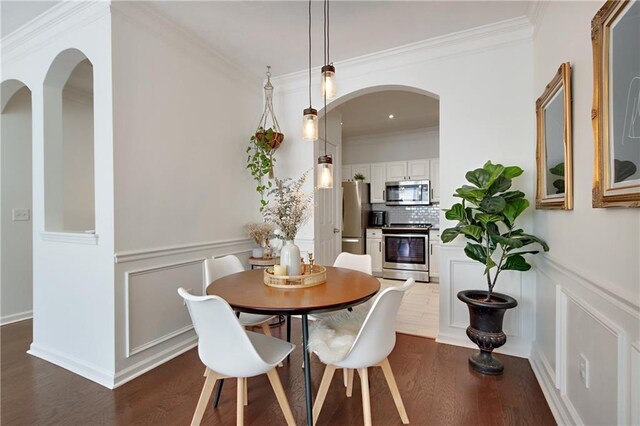 1850 Cotillion Dr Unit 2304, Dunwoody, GA 30338 - dining space with crown molding, dark wood-type flooring, a decorative wall, arched walkways, and wainscoting
