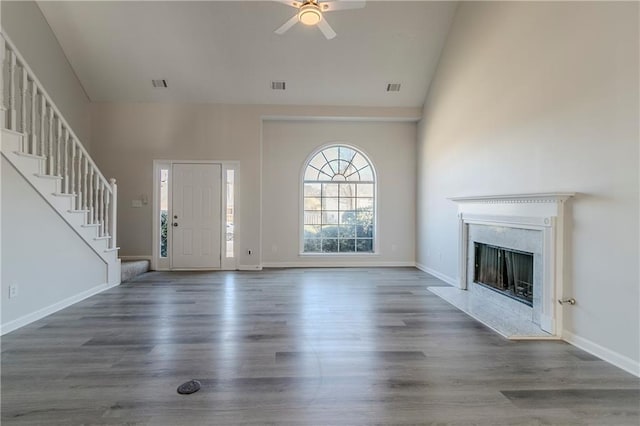 unfurnished living room featuring a high end fireplace, high vaulted ceiling, ceiling fan, and hardwood / wood-style flooring