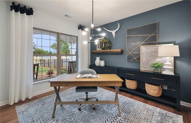 home office with a wealth of natural light, dark hardwood / wood-style flooring, and an inviting chandelier