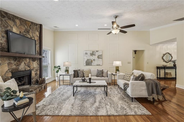 255 Broken Lance Pl, Johns Creek, GA 30022 - living room with a textured ceiling, crown molding, a ceiling fan, a fireplace, and wood finished floors