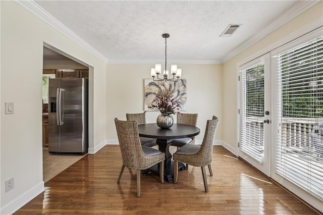 255 Broken Lance Pl, Johns Creek, GA 30022 - dining space featuring a chandelier, wood finished floors, crown molding, french doors, and a textured ceiling
