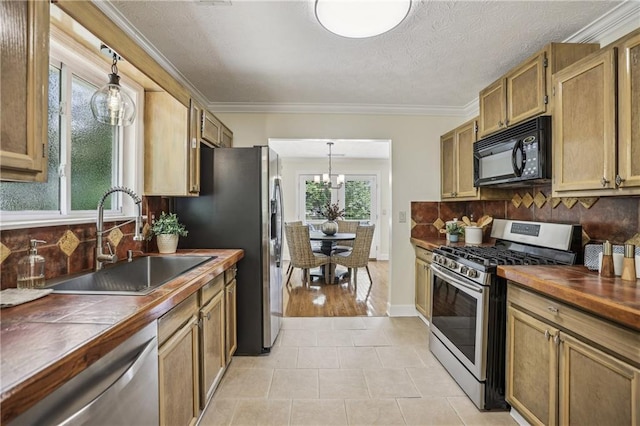 255 Broken Lance Pl, Johns Creek, GA 30022 - kitchen with appliances with stainless steel finishes, a sink, tasteful backsplash, light tile patterned floors, and crown molding