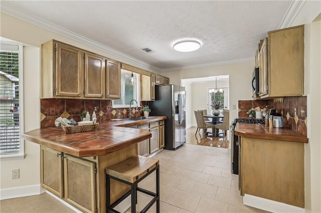 255 Broken Lance Pl, Johns Creek, GA 30022 - kitchen with appliances with stainless steel finishes, a sink, tile countertops, plenty of natural light, and ornamental molding