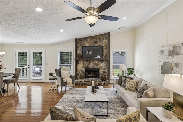 255 Broken Lance Pl, Johns Creek, GA 30022 - living room with wood finished floors, a textured ceiling, ornamental molding, a stone fireplace, and ceiling fan