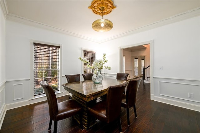 dining space with dark wood finished floors, stairs, a decorative wall, and ornamental molding