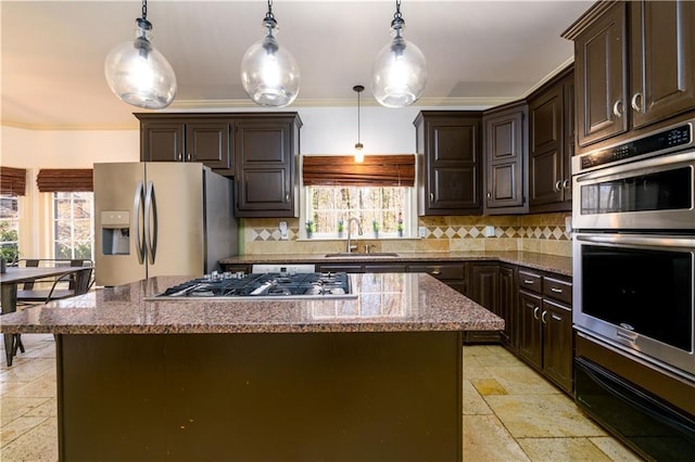 kitchen with crown molding, stainless steel appliances, decorative backsplash, a sink, and stone tile flooring