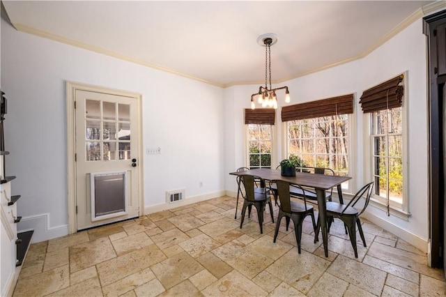 dining room with baseboards, stone tile floors, ornamental molding, and a chandelier