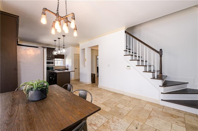 dining space featuring stone tile floors, stairs, an inviting chandelier, ornamental molding, and baseboards