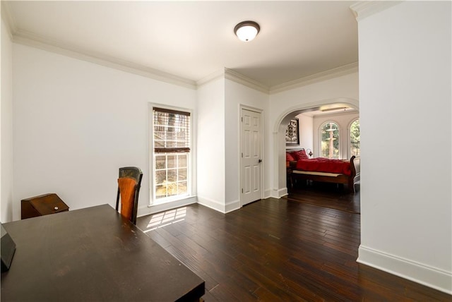 office space with arched walkways, crown molding, baseboards, and hardwood / wood-style flooring