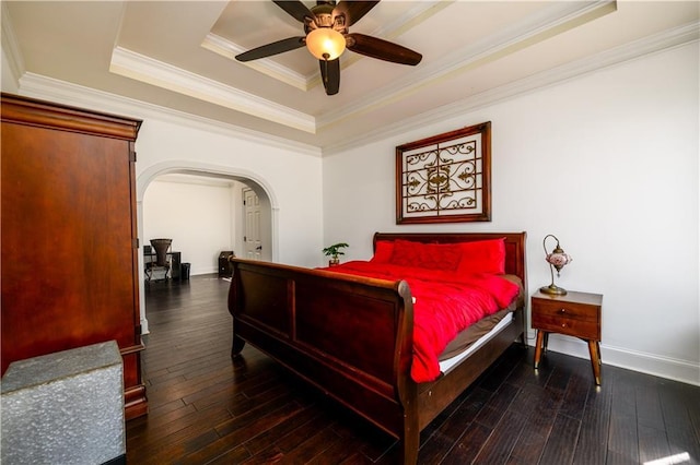 bedroom with a raised ceiling, hardwood / wood-style flooring, arched walkways, crown molding, and baseboards