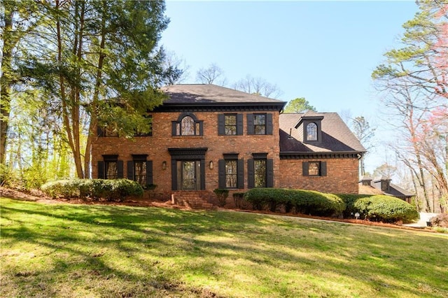 view of front facade featuring brick siding and a front yard