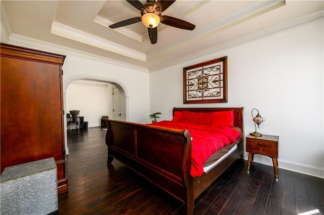 bedroom with hardwood / wood-style flooring, baseboards, ornamental molding, arched walkways, and a tray ceiling