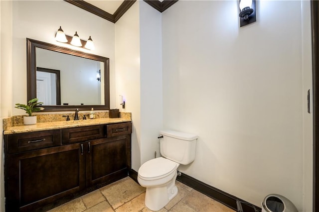 half bath featuring crown molding, baseboards, toilet, stone tile flooring, and vanity