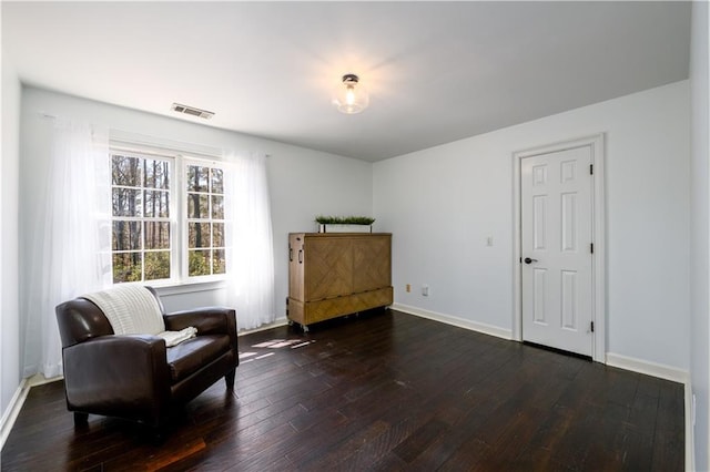 sitting room featuring dark wood-style floors, visible vents, and baseboards