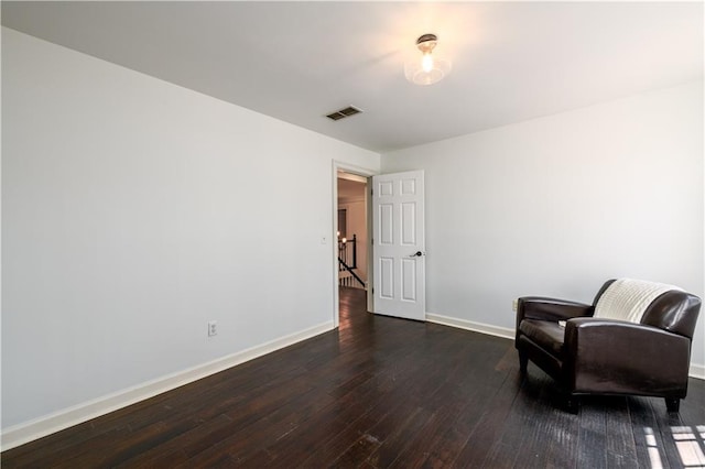 sitting room with dark wood-style flooring, baseboards, and visible vents