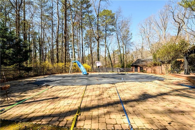 view of swimming pool featuring a fenced in pool, a patio, a water slide, and fence