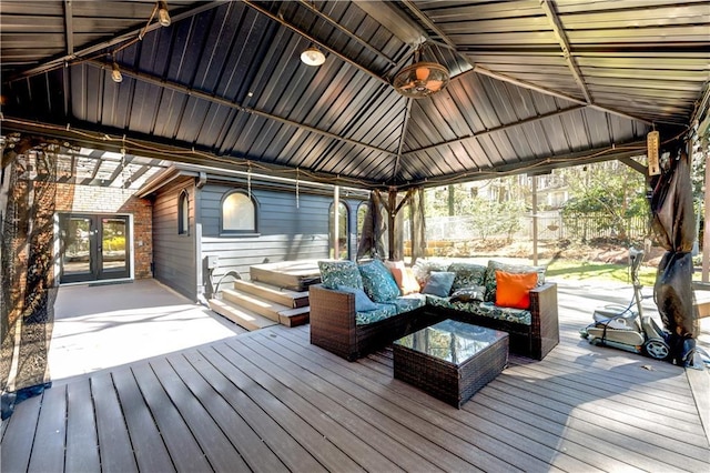 wooden terrace with fence, french doors, a gazebo, ceiling fan, and outdoor lounge area