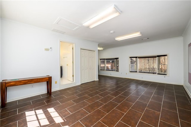 spare room with baseboards, visible vents, and attic access