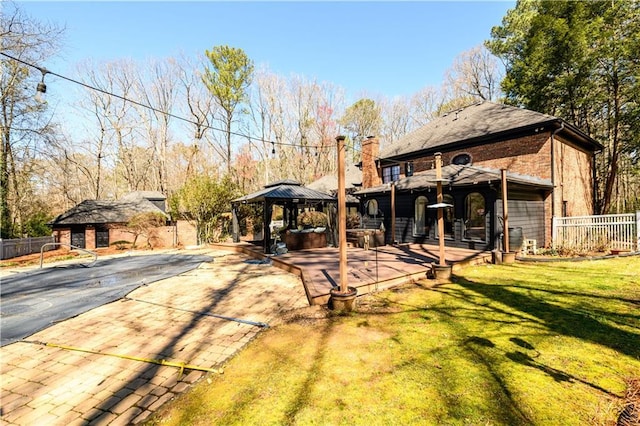 view of yard featuring a gazebo, fence, and an outbuilding