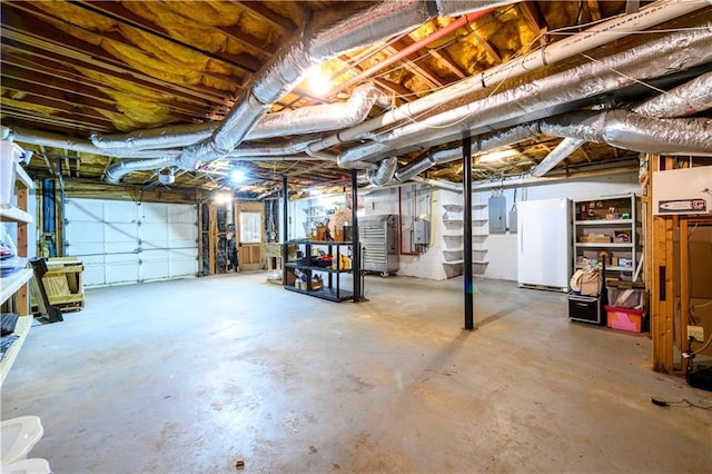 unfinished basement featuring electric panel and freestanding refrigerator