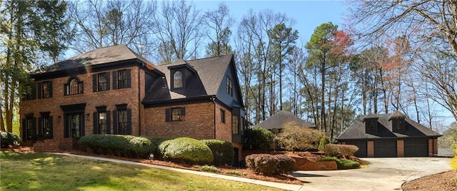view of side of property featuring concrete driveway, an outdoor structure, brick siding, a lawn, and a garage