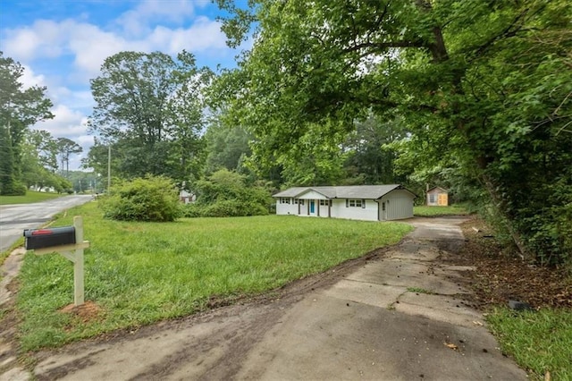 2091 Chestnut Log Dr, Lithia Springs, GA 30122 - view of green lawn featuring driveway and an outdoor structure