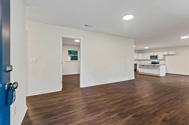 2091 Chestnut Log Dr, Lithia Springs, GA 30122 - unfurnished living room with dark wood-style floors, recessed lighting, and baseboards