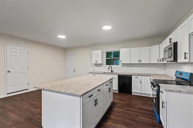 2091 Chestnut Log Dr, Lithia Springs, GA 30122 - kitchen with appliances with stainless steel finishes, a sink, dark wood-type flooring, a kitchen island, and recessed lighting