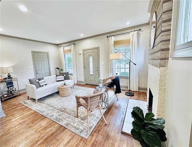 living room with baseboards, light wood-type flooring, and a wealth of natural light