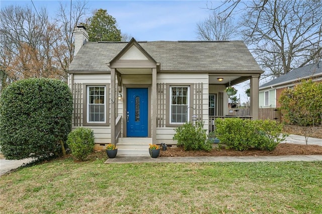 bungalow featuring crawl space, roof with shingles, a chimney, and a front lawn