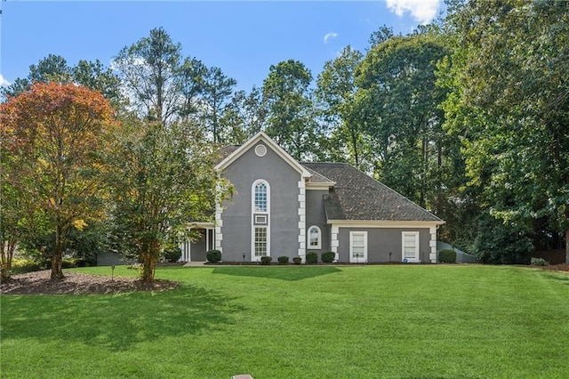 view of front facade with a front yard and stucco siding