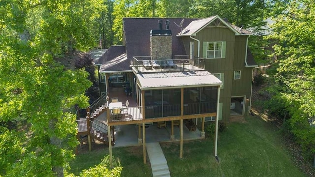 210 Lake Pines Rd, Jackson, GA 30233 - rear view of property with a sunroom, stairway, a lawn, a chimney, and board and batten siding