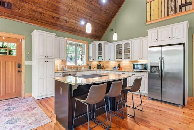210 Lake Pines Rd, Jackson, GA 30233 - kitchen with stainless steel appliances, white cabinetry, glass insert cabinets, light stone countertops, and wooden ceiling