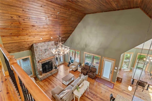 210 Lake Pines Rd, Jackson, GA 30233 - living room with a chandelier, wood ceiling, a stone fireplace, high vaulted ceiling, and hardwood / wood-style floors
