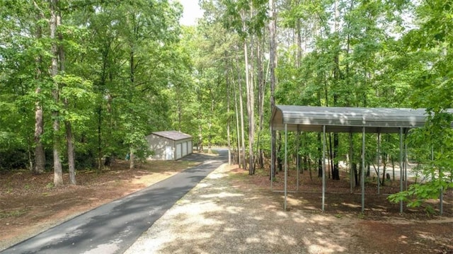 210 Lake Pines Rd, Jackson, GA 30233 - surrounding community with a forest view, an outdoor structure, and a detached carport