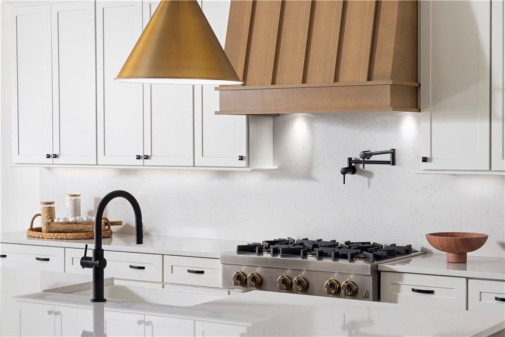kitchen featuring a sink, light countertops, stainless steel gas cooktop, and white cabinetry